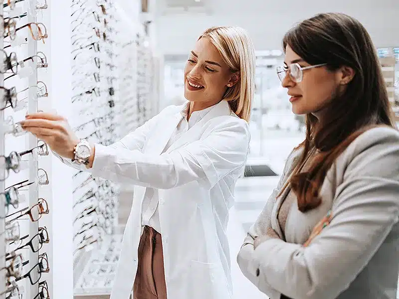 doctor showing lady glasses from display