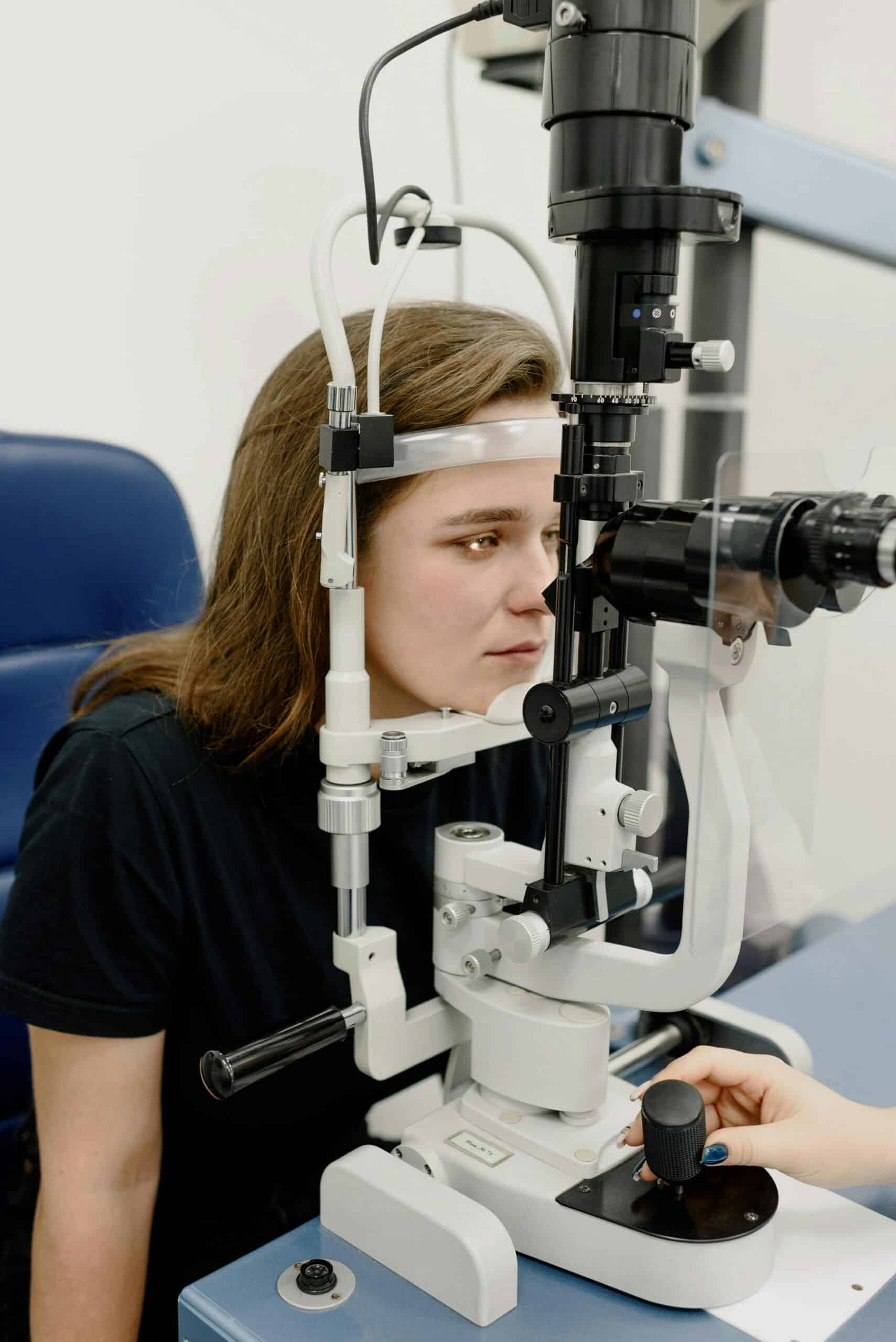 optometrist putting glasses on patient