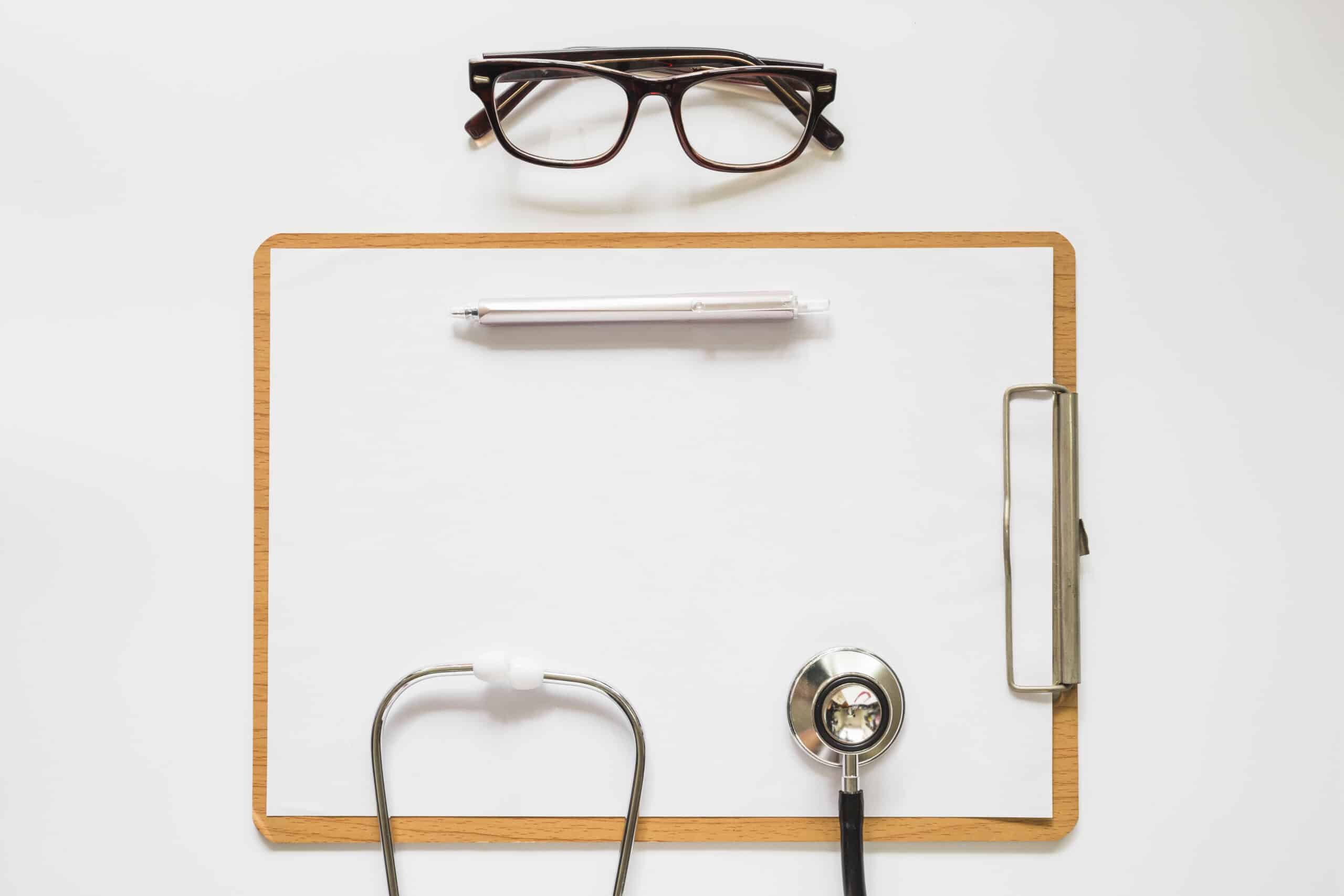 optometrist putting glasses on patient