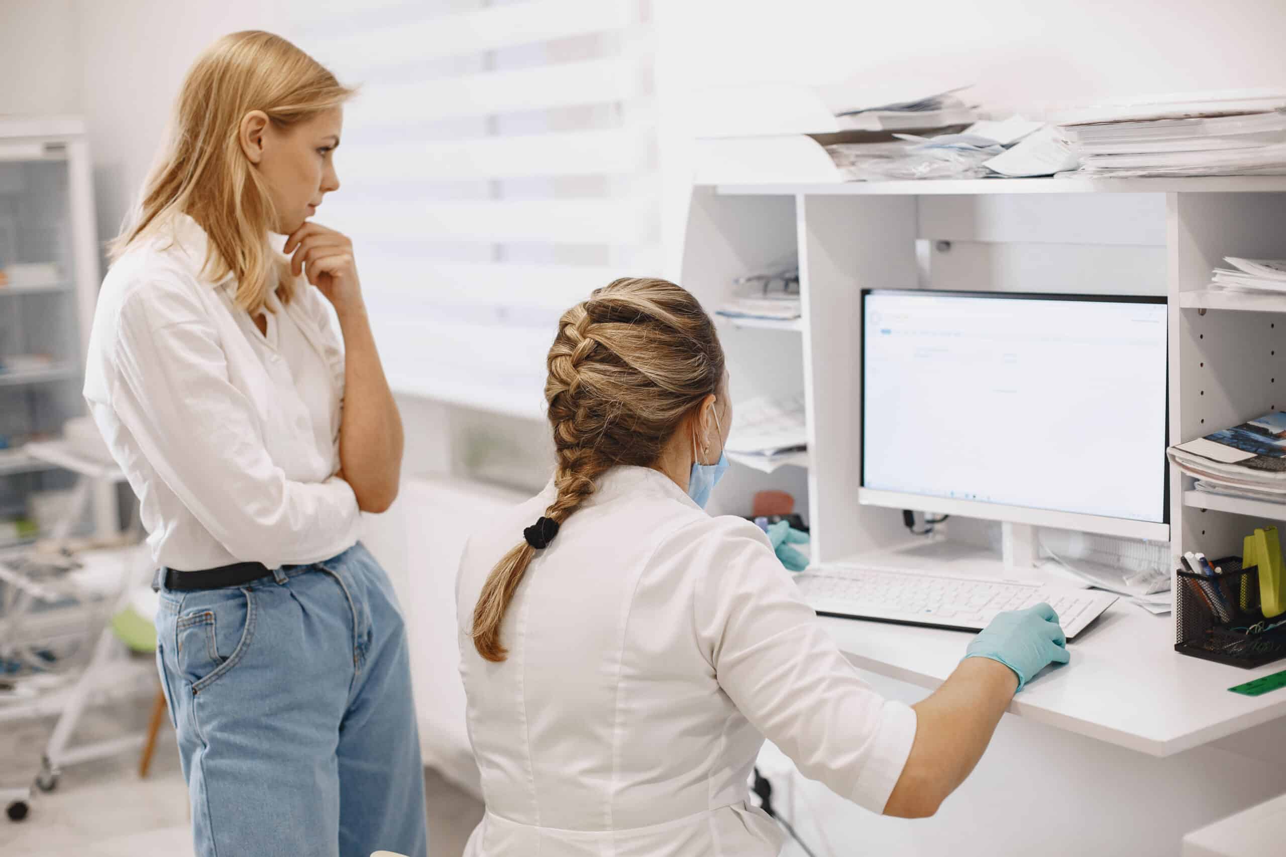 optometrist putting glasses on patient