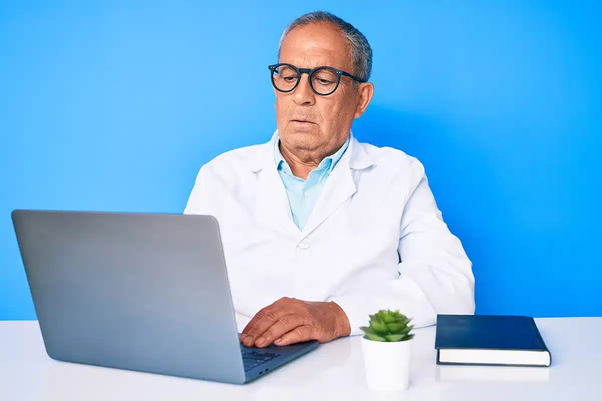 optometrist putting glasses on patient