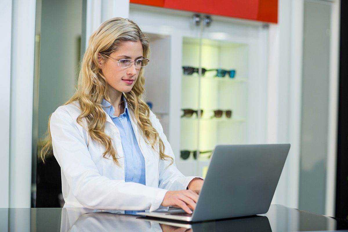 Optometrist using laptop in ophthalmology clinic