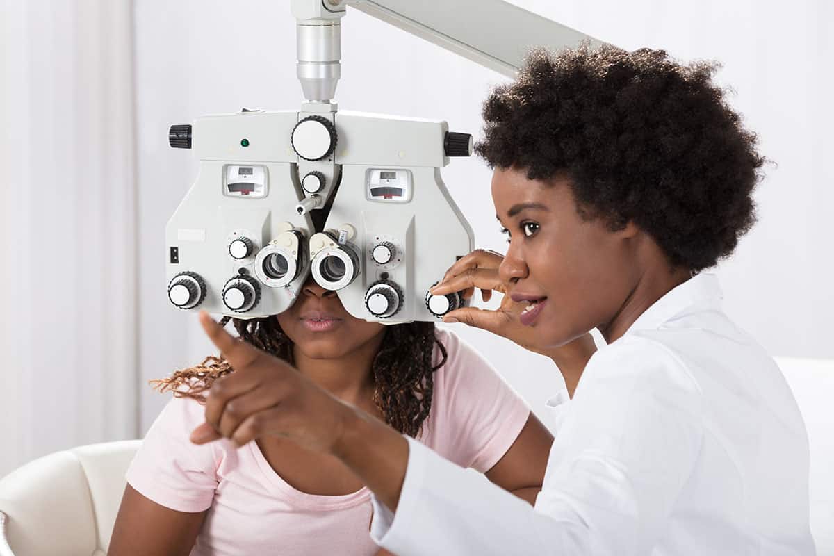 optometrist preforming eye exam on client optometrist preforming eye exam on client