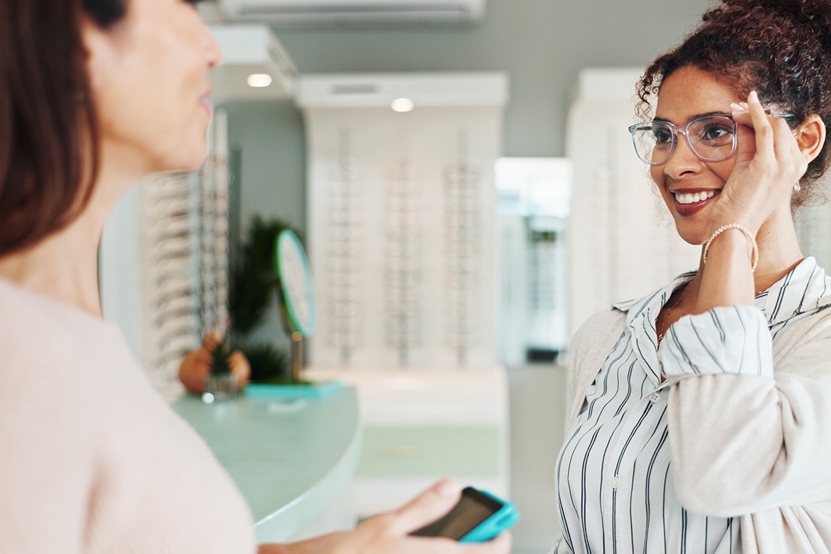 woman trying on glasses at store