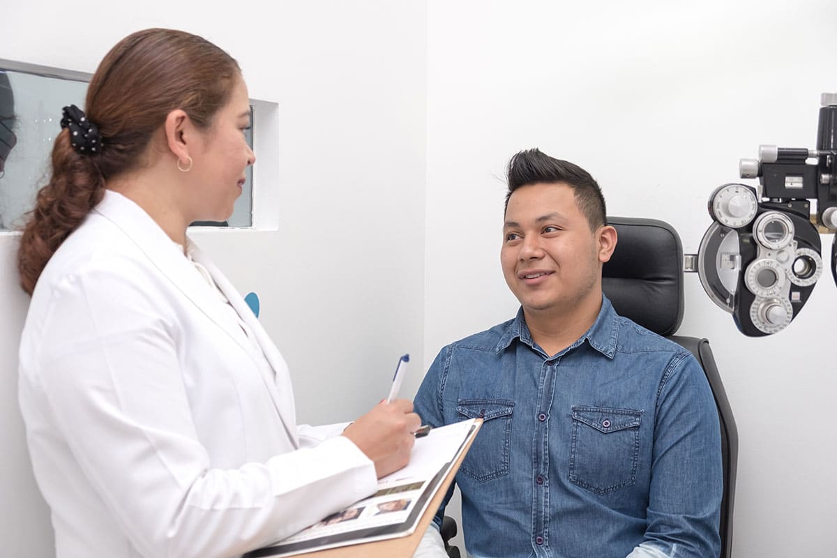 An eye doctor performing an eye exam on patient.
