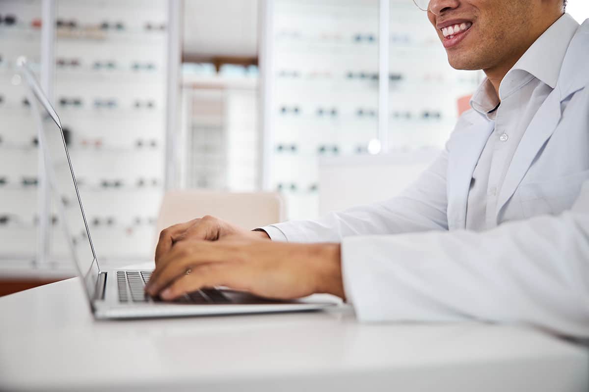 eye doctor sitting in front of laptop