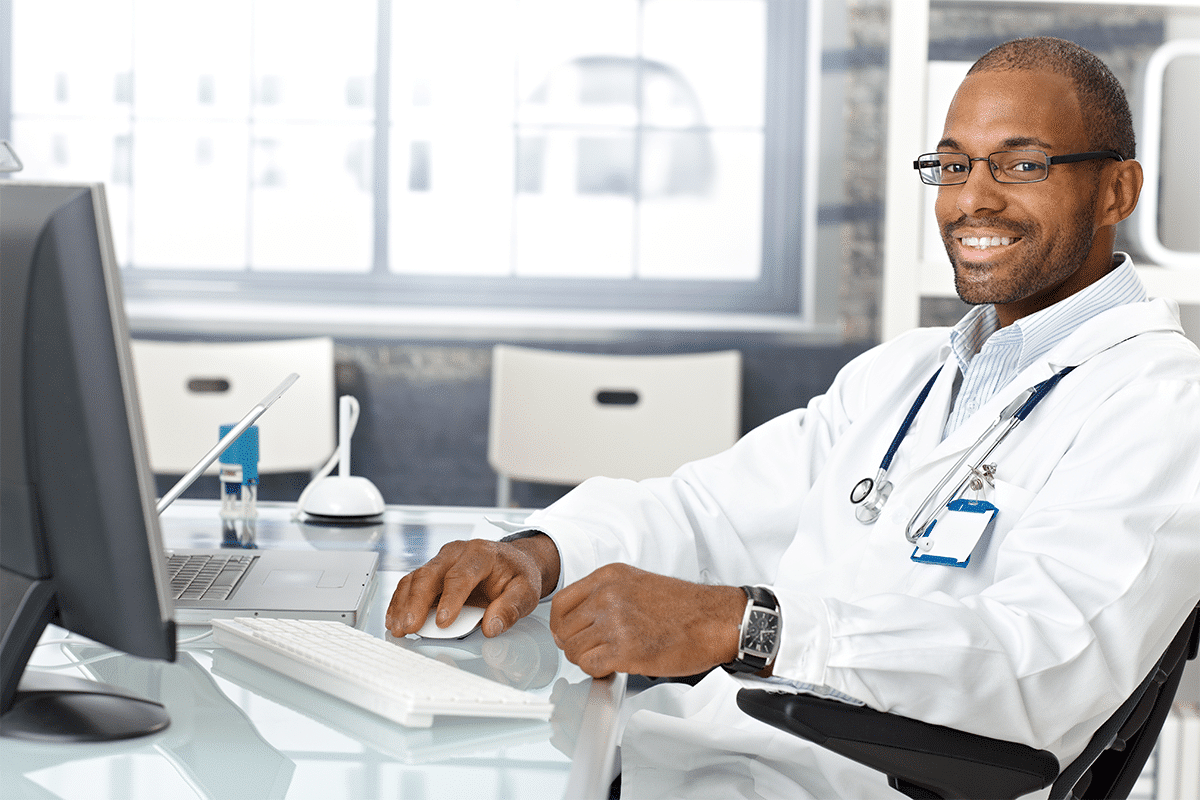 eye doctor sitting in front of laptop