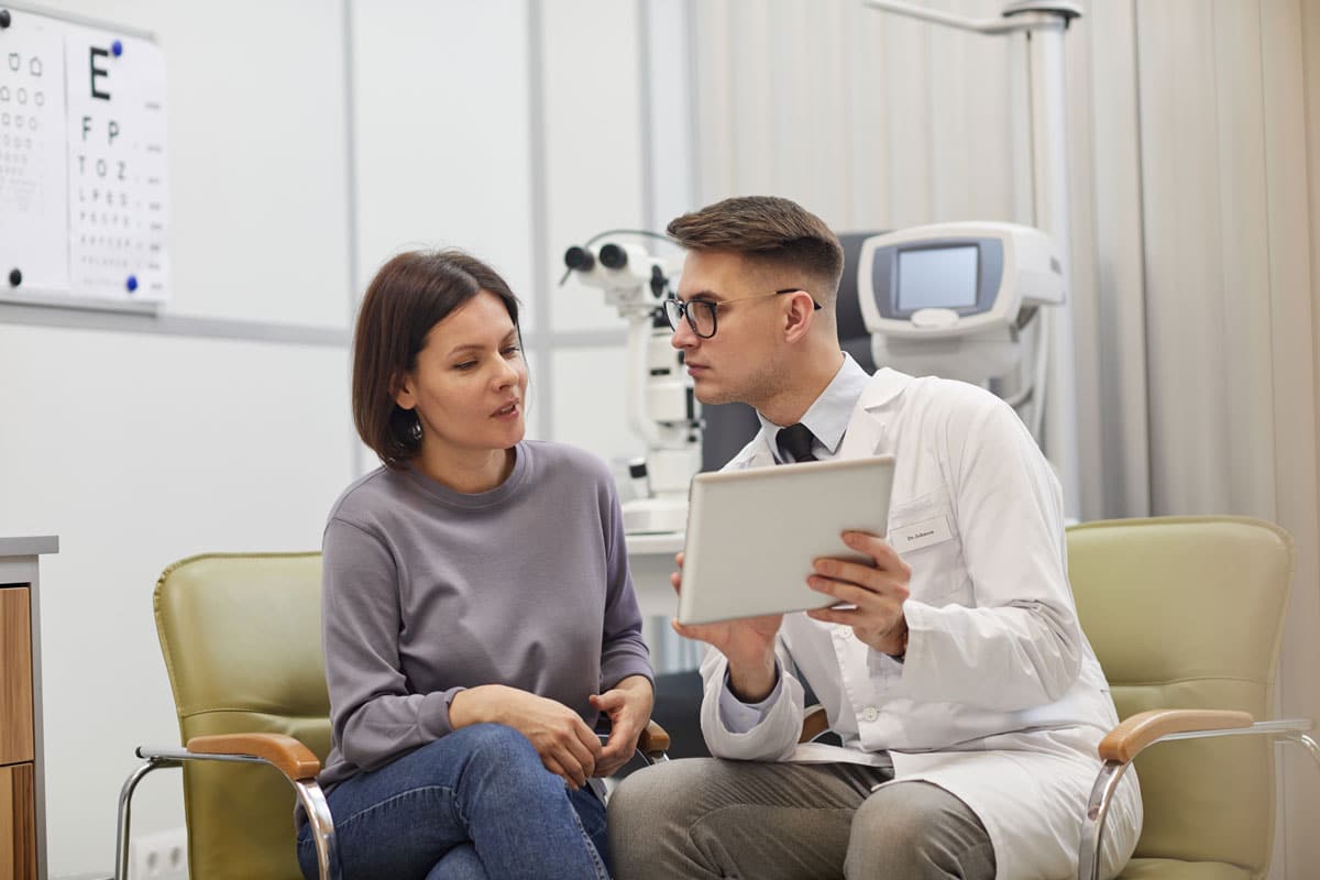 optometrist showing a patient information on a tablet